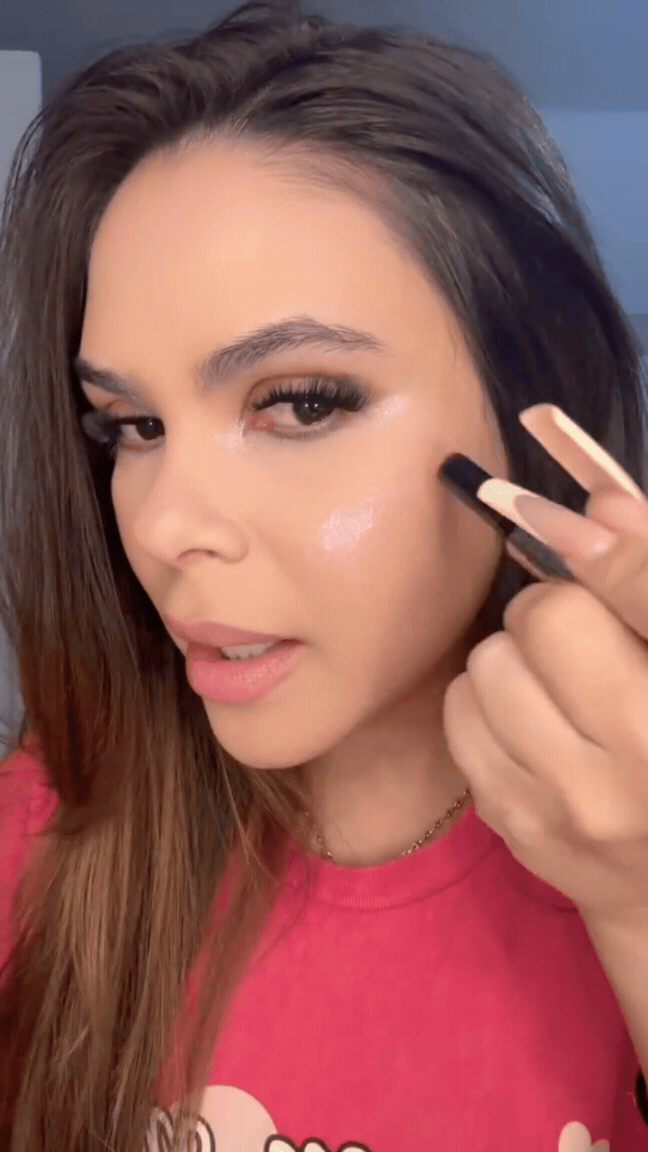 Using a shimmer makeup stick to add glow to the cheek area